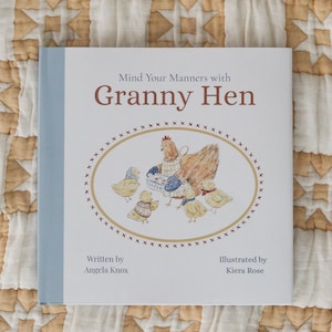 Puede incluir: Un libro infantil cuadrado titulado Mind Your Manners with Granny Hen, escrito por Angela Knox e ilustrado por Kiera Rose. La portada presenta una ilustración ovalada central de una gallina y pollitos, con un lomo azul claro y fondo blanco.