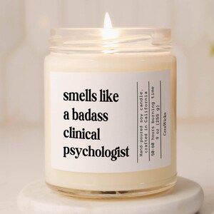 A candle jar with the label saying Smells likea badass clinical psychologist candle