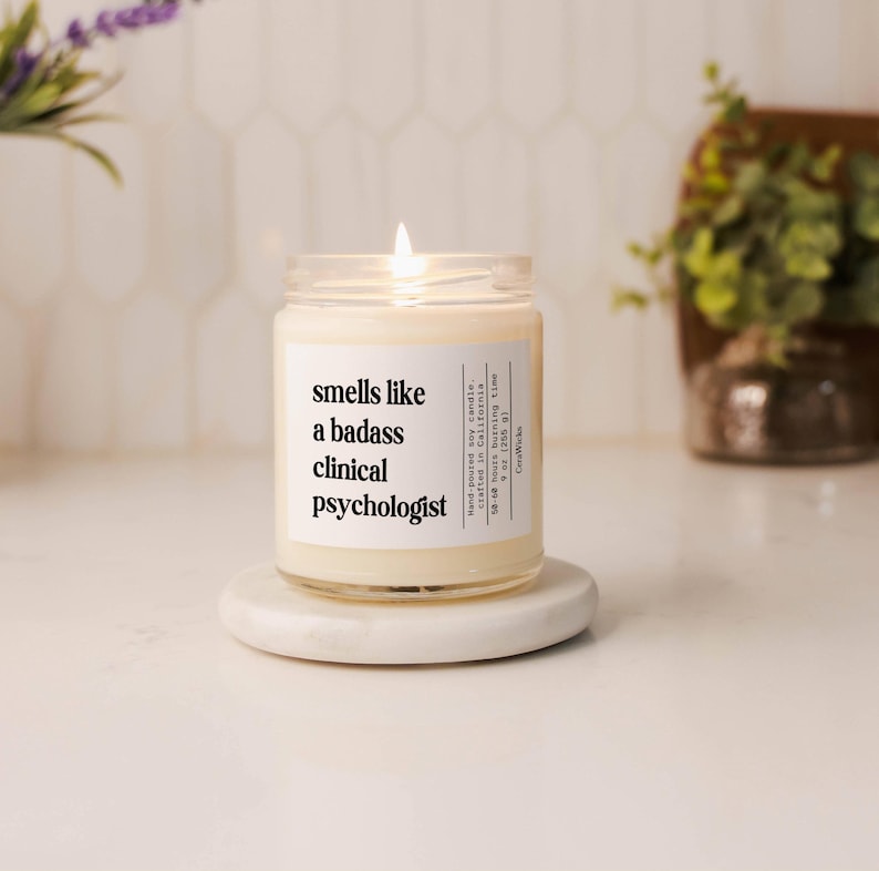 A candle jar with the label saying Smells likea badass clinical psychologist candle