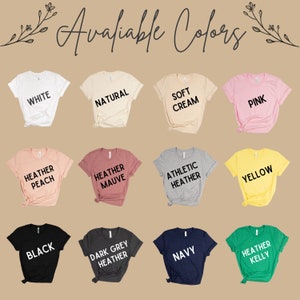 May include: A selection of t-shirts in various colors, including white, natural, soft cream, pink, heather peach, heather mauve, athletic heather, yellow, black, dark grey heather, navy, and heather kelly.
