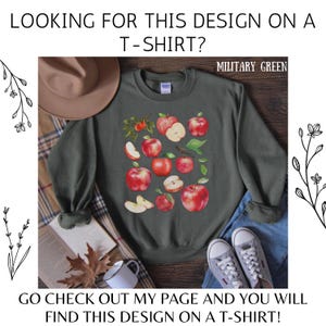 Pu&ograve; includere: Una felpa verde militare con un design grafico di mele rosse e foglie. Il testo "MILITARY GREEN" &egrave; stampato nell'angolo in alto a destra della felpa.
