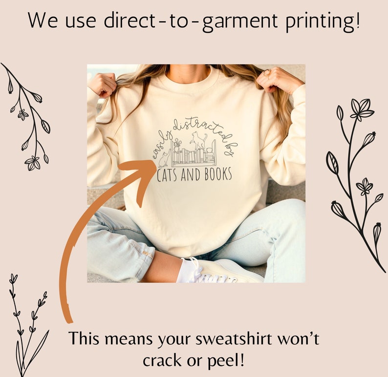 May include: A cream colored sweatshirt with the text "easily distracted by cats and books" in black. The text is in a semi-circle with a graphic of cats and books inside the circle.