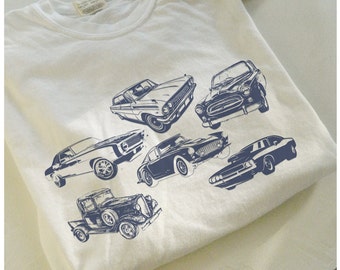 Puede incluir: Una camiseta blanca con un estampado azul de seis coches antiguos. Los coches son todos de diferentes marcas y modelos, y todos están mirando hacia adelante. La camiseta es una gran manera de mostrar tu amor por los coches clásicos.
