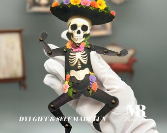May include: A black skeleton wearing a sombrero with colorful flowers, a floral garland, and a black and white skeleton design. The skeleton is posed with arms outstretched and legs bent. The text "DIY GIFT & SELF MADE FUN" is visible at the bottom of the image.