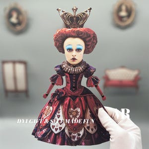 May include: A red and white Queen of Hearts doll with a crown and a heart-shaped dress. The doll is holding a playing card that says "DIY Gift & Self Made Fun".