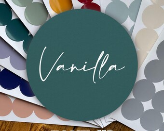 Könnte beinhalten: Ein türkisfarbener Kreis mit dem Wort "Vanilla" in weißer Kursivschrift. Der Kreis ist von einer Vielzahl von farbigen Kreisen umgeben, darunter beige, grau und rot. Der Text "FONT #1" ist in Schwarz unter dem Kreis geschrieben.