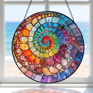 May include: A round, stained glass window hanging with a spiral design. The mosaic features a vibrant array of colors, including red, orange, yellow, green, blue, and purple. It is framed in black and suspended by a chain.