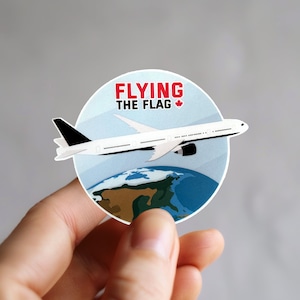 Peut inclure: Un avion blanc volant au-dessus d'un globe terrestre bleu et vert avec le texte "FLYING THE FLAG" et un icône du drapeau canadien.