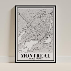 Peut inclure: Une affiche encadrée de la carte de Montréal, Québec, Canada. La carte est en niveaux de gris, montrant la disposition de la ville avec les routes, les cours d'eau et les parcs. Le nom de la ville est affiché en lettres majuscules noires en gras, avec "Québec, Canada" en dessous.