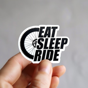 Peut inclure: Autocollant noir et blanc avec une roue de vélo et le texte "Eat Sleep Ride".