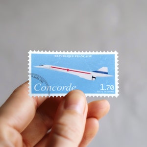 Peut inclure: Un timbre-poste bleu et blanc représentant un avion supersonique Concorde blanc avec une bande rouge et blanche sur le fuselage. Le timbre porte les inscriptions "REPUBLIQUE FRANCAISE" et "Concorde" avec une valeur de "1.70 POSTE AERIENNE".