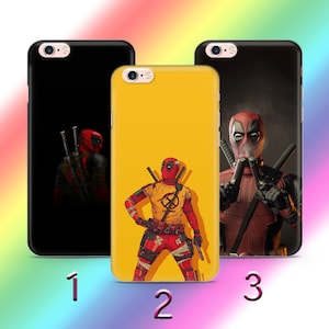 Puede incluir: Tres fundas de teléfono diferentes con el superhéroe Deadpool. La primera funda es negra con una silueta de Deadpool. La segunda funda es amarilla con una imagen de dibujos animados de Deadpool. La tercera funda es negra con una foto de Deadpool sosteniendo dos pistolas.