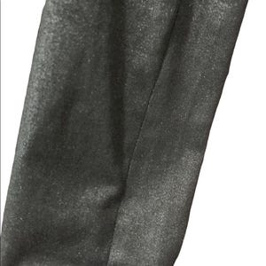 May include: Close-up of a section of black fabric with a subtle sheen. The fabric is divided by a vertical seam, creating two distinct panels. The texture appears smooth with a slight shimmer, suggesting a formal or evening wear material.