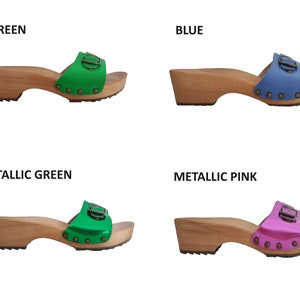 May include: Four pairs of wooden platform clogs with different colored straps. The straps are green, blue, metallic green, and metallic pink.