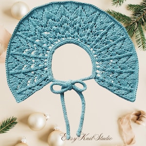 May include: A teal blue knitted collar with a semi-circular shape and a decorative leaf-like lace pattern. The collar features a smooth stockinette stitch border along the inner and outer edges and includes two long knitted ties that form a bow.
