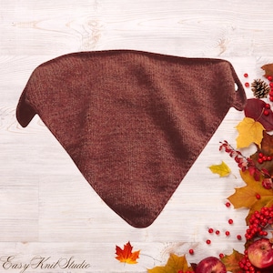 May include: A triangular-shaped knitted bandana in a solid dark brown color. The accessory features a consistent stockinette stitch pattern throughout, with two pointed ends at the top corners and a single point at the bottom center.