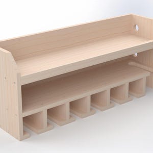 May include: A light-coloured wooden tool organiser with two shelves and multiple slots. The top shelf has a raised back, and the side features a circular hole. The bottom shelf has slots for tool storage.