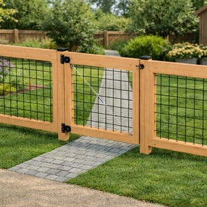 May include: A wooden fence with a gate, featuring a black wire mesh. The fence and gate are made of light-coloured wood. The gate is open, revealing a stone pathway leading into a garden with green grass and colourful flowers.