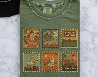May include: Moss green t-shirt with six vintage-style postage stamp illustrations. The stamps depict scenes related to tea, including people drinking tea, teapots, and the text "HOT CHAI". The shirt is made by Comfort Colors.