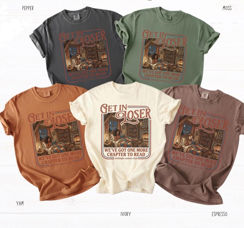 Op de afbeelding: Vijf t-shirts in verschillende kleuren: grijs, groen, oranje, cr&egrave;me en bruin. Elk shirt heeft een afbeelding met de tekst "Get In Closer" en "We've Got One More Chapter to Read". De afbeelding toont een persoon die leest in een kamer.