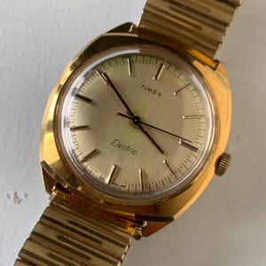 1979 England DIal Timex Electric Watch, Square-ish Goldtone Case w/Golden Dial. Decent Overall Condition with Period Expanding Band. Works!