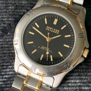 Outland Watch 1990s - Diver Style, Silver tone w/gold tone accents, Black Dial, Good Condition, Good Weight, Works Well. New Battery.