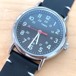 Timex Black Dial Indiglo Quartz Watch - Large Silver Tone w/Black Dial. Good Condition, Indiglo Bright through the Black! New Leather Strap.