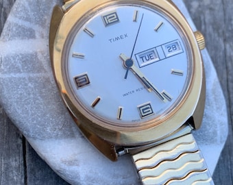 1975 Timex Marlin Winder Watch, Goldtone Case w/Champagne Calendar Dial. Decent Overall Condition with Period Expanding Band. Works!