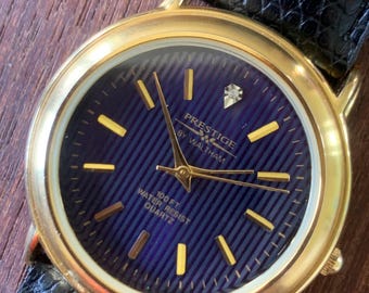 Prestige by Waltham Diamond Dial Quartz Watch.  Gold Tone with striped dial, black and deep blue. Classic Retro Style. Leather Band. Unworn.