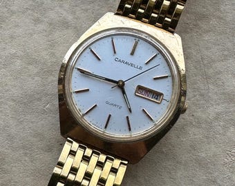 1980s Caravelle by Bolova Quartz Watch Gold Tone Finish, White Dial with Day/Date New battery. New Metal Bracelet. Overall Decent Condition
