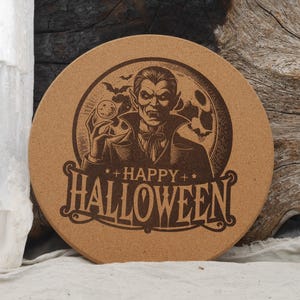 May include: Round, brown cork coaster with a Halloween theme. The coaster features a detailed illustration of a vampire holding a clock, with bats and a skull in the background. The words "HAPPY HALLOWEEN" are prominently displayed.