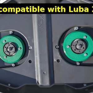 Könnte beinhalten: Nahaufnahme einer dunkelgrauen Maschinenkomponente mit zwei kreisförmigen grünen und schwarzen Teilen. Der Text "Now compatible with Luba 2025" ist gelb am oberen Bildrand zu sehen.