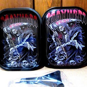 May include: Two black rolling trays with a grim reaper design. The trays feature a skull-faced figure in a dark cloak holding a scythe, with the word "MAYHEM" above. A black tool is in the foreground.