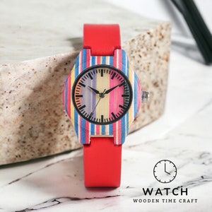 Elegant ladies quartz wristwatch featuring colorful stripes on a bamboo wood face, secured with a pin buckle on a genuine leather watchband. Ideal for casual wear.