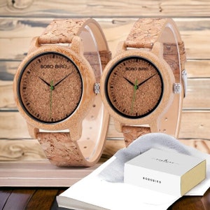 Pair of elegant wooden wristwatches with cork straps, presented in a luxury box. The bamboo watch face features a custom logo, making it a unique gift for couples. Handcrafted with attention to detail.