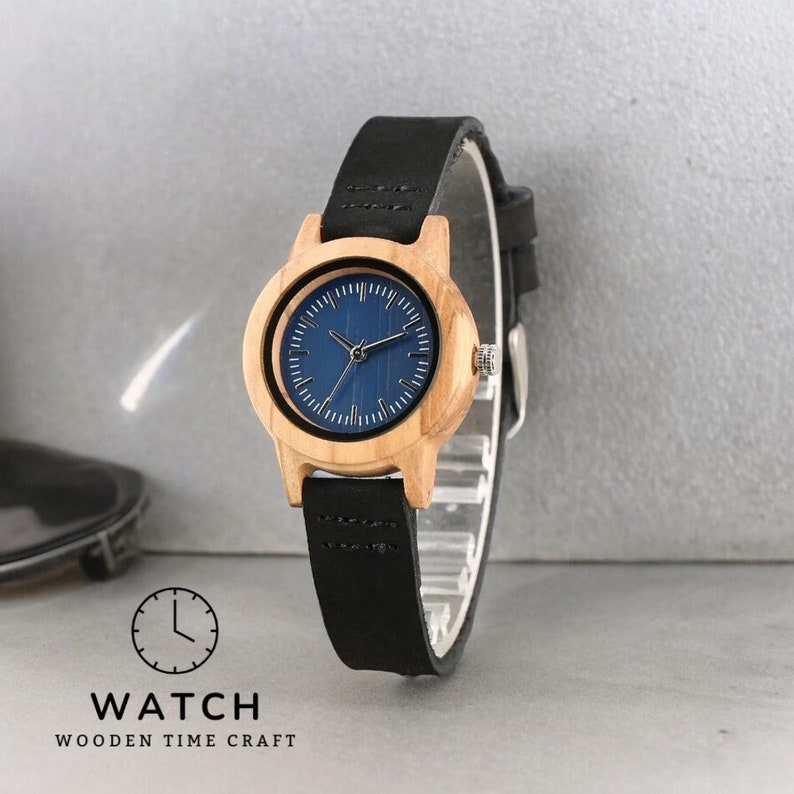 Stylish minimalist women watch featuring a vibrant blue dial, encased in natural bamboo wood. Slim genuine leather wristband complements this elegant timepiece, perfect for fashion-forward ladies.