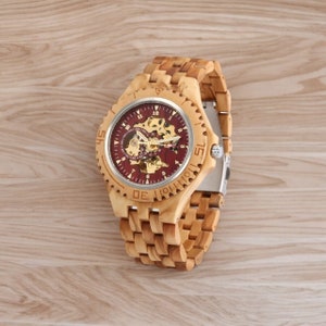 Gold-toned automatic men watch with Arabic numerals on a full wood bracelet and case. Eco-friendly, self-winding wristwatch with a clear analog display.