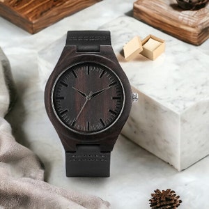 Classic ebony wood quartz men watch with a minimalist scale, round dial, and black genuine leather strap. Fashionable and casual accessory for men.