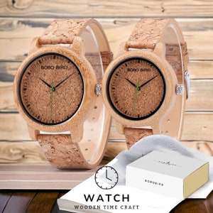 Pair of elegant wooden wristwatches with cork straps, presented in a luxury box. The bamboo watch face features a custom logo, making it a unique gift for couples. Handcrafted with attention to detail.