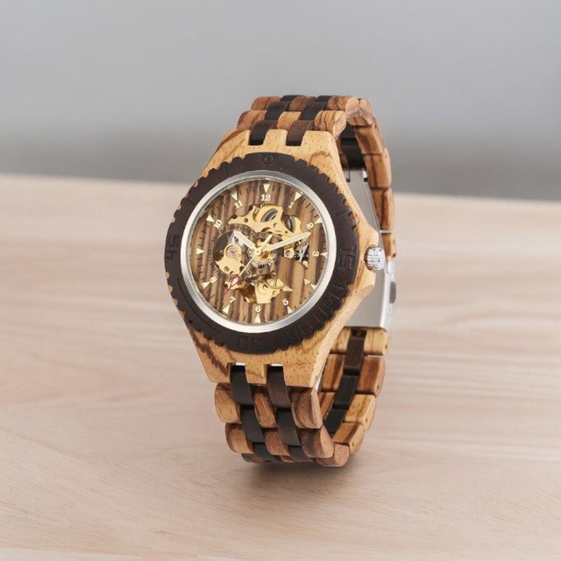 Gold-toned automatic men watch with Arabic numerals on a full wood bracelet and case. Eco-friendly, self-winding wristwatch with a clear analog display.