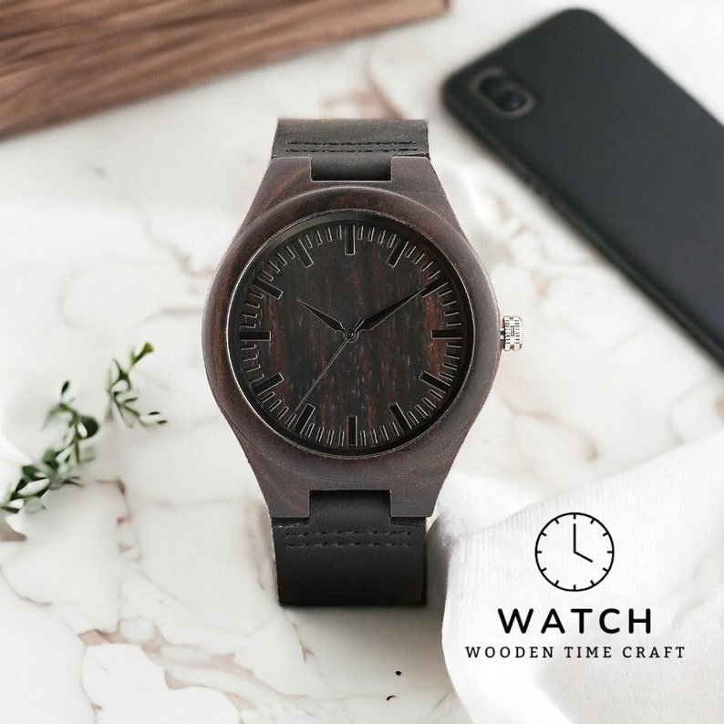 Classic ebony wood quartz men watch with a minimalist scale, round dial, and black genuine leather strap. Fashionable and casual accessory for men.