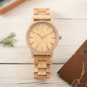 Men wristwatch crafted from Red Wood, Maple, and Ebony, featuring a full wooden case and bangle. Includes a quartz movement and folding clasp for secure wear. Eco-friendly and stylish timepiece for men.