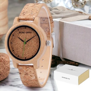 Pair of elegant wooden wristwatches with cork straps, presented in a luxury box. The bamboo watch face features a custom logo, making it a unique gift for couples. Handcrafted with attention to detail.