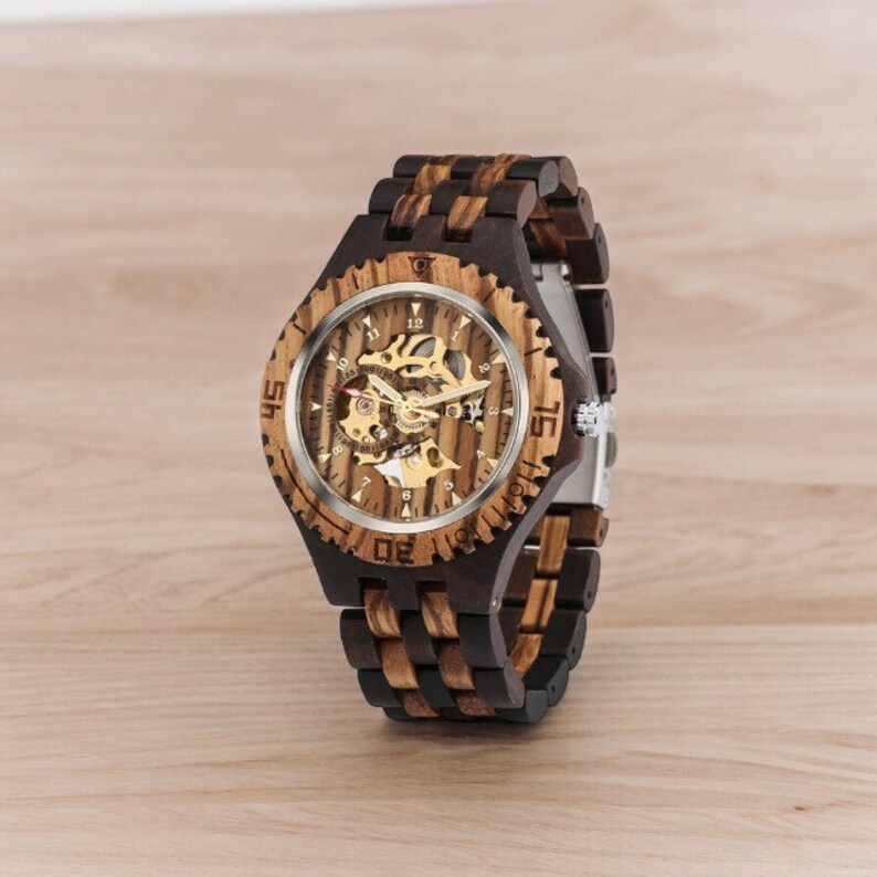 Gold-toned automatic men watch with Arabic numerals on a full wood bracelet and case. Eco-friendly, self-winding wristwatch with a clear analog display.