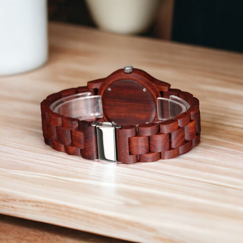 Men wristwatch crafted from Red Wood, Maple, and Ebony, featuring a full wooden case and bangle. Includes a quartz movement and folding clasp for secure wear. Eco-friendly and stylish timepiece for men.