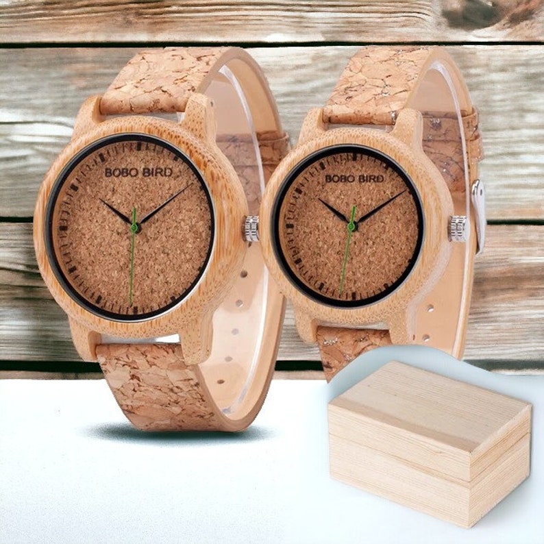 Pair of elegant wooden wristwatches with cork straps, presented in a luxury box. The bamboo watch face features a custom logo, making it a unique gift for couples. Handcrafted with attention to detail.