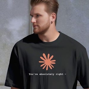 May include: Black t-shirt with a coral-colored flower graphic and the text "You're absolutely right -". The shirt is made of a soft material and has short sleeves.