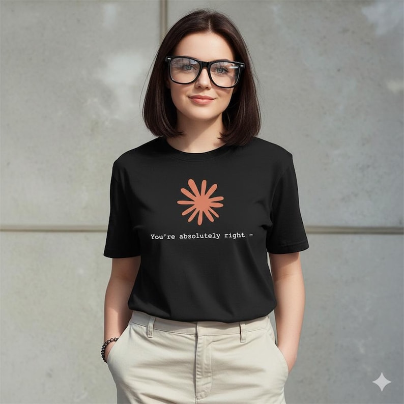 May include: A black t-shirt with a coral-colored floral design and the text "You're absolutely right -" in white. The shirt is worn by a person wearing glasses and light-colored pants.