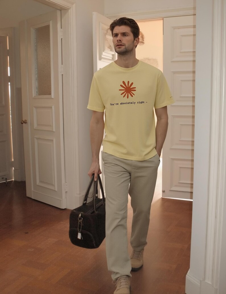 May include: A person wearing a yellow t-shirt with a red floral design and the text "You're absolutely right -" paired with khaki pants and tan shoes. They are carrying a black duffel bag.