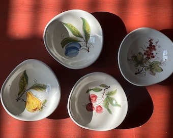 May include: Four white ceramic bowls with different fruit designs. The bowls are painted with green leaves, red cherries, yellow pears, and blue plums.